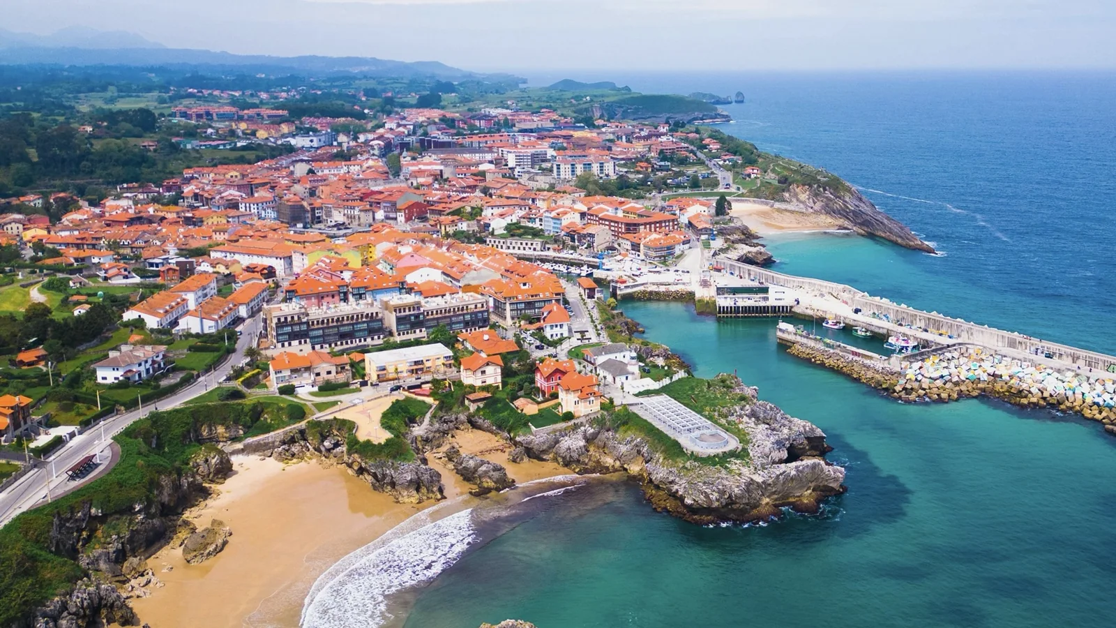 Vista aérea de Llanes con el puerto, la costa y el casco urbano