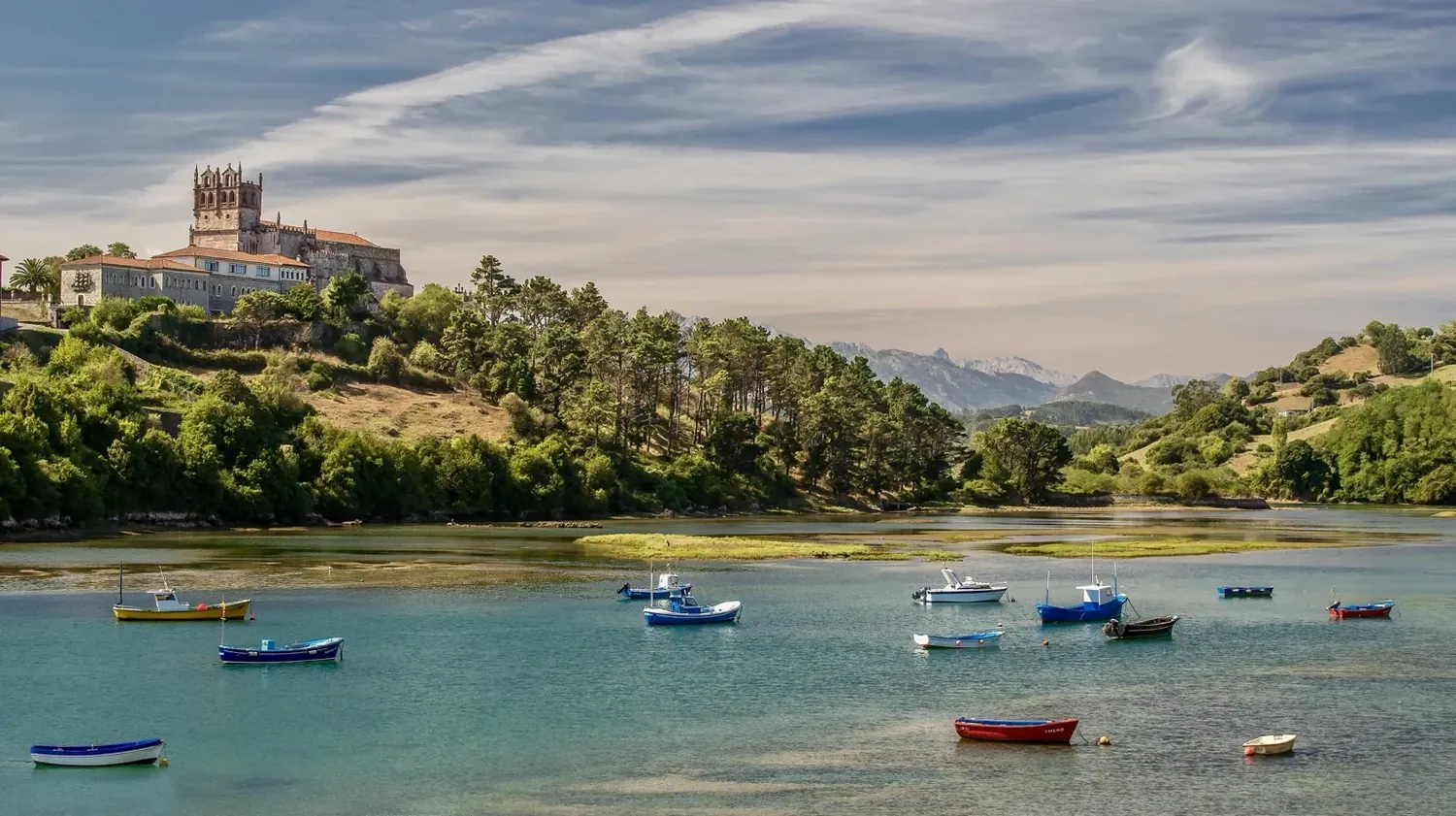 San Vicente de la Barquera con ría, barcos y montañas al fondo