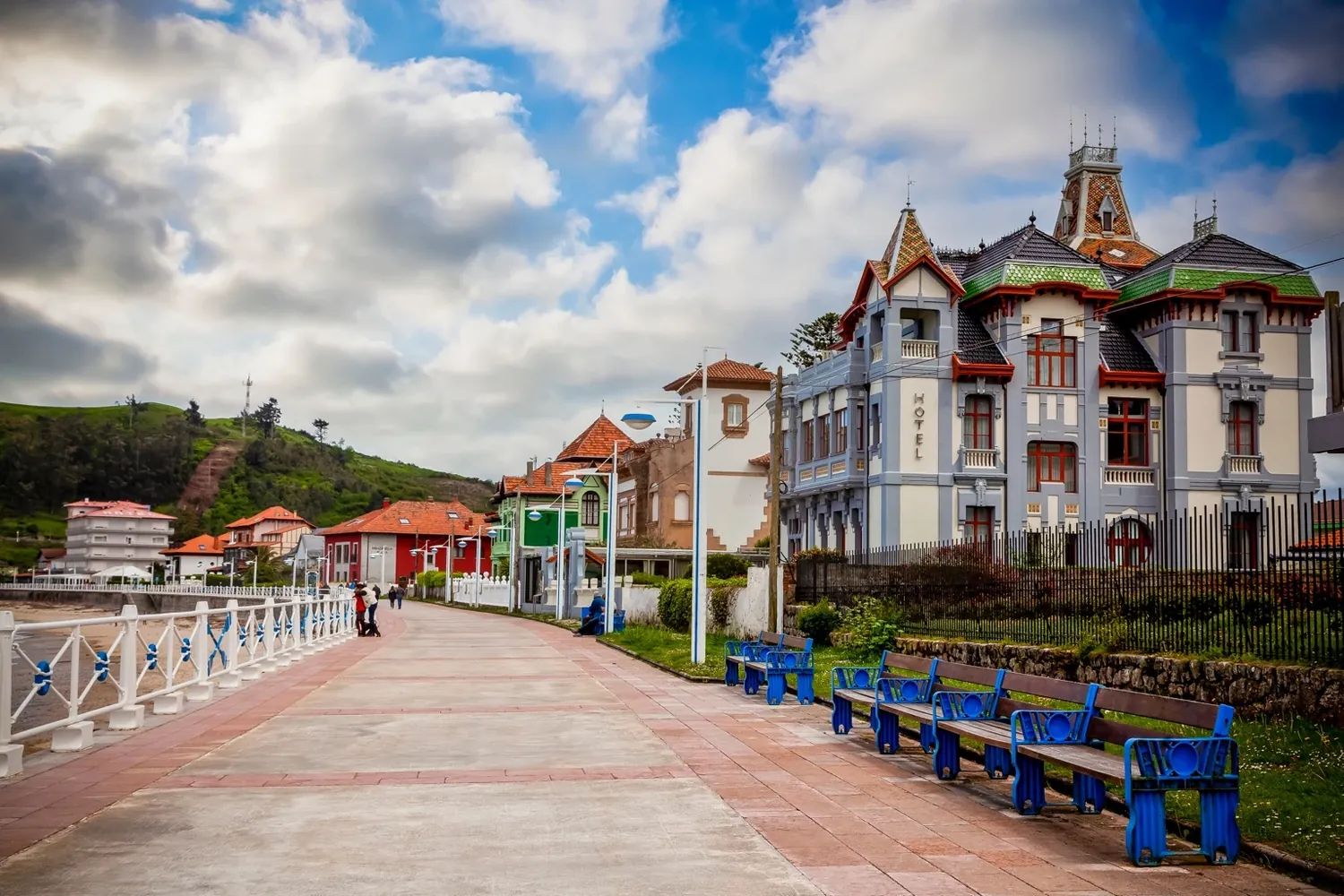 Ribadesella con paseo marítimo, bancos azules y casas indianas
